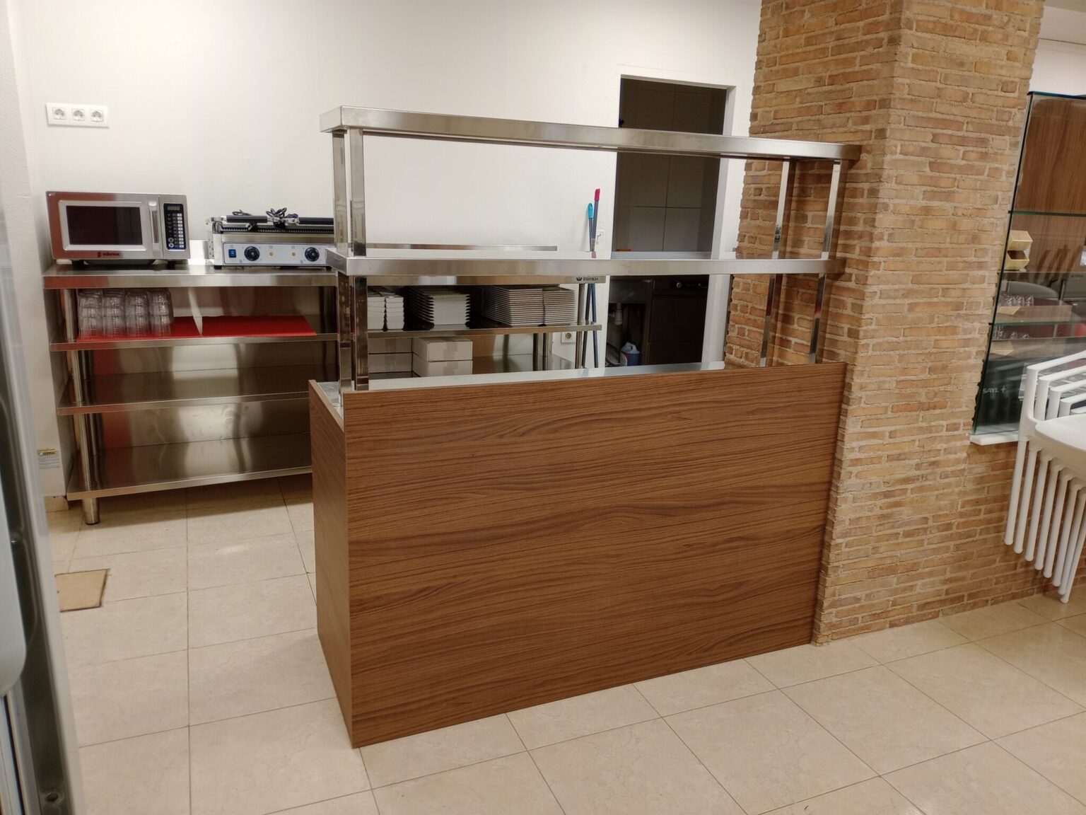 Cocina a medida en Castellón de la Plana con iluminación LED integrada y muebles de madera blanca.